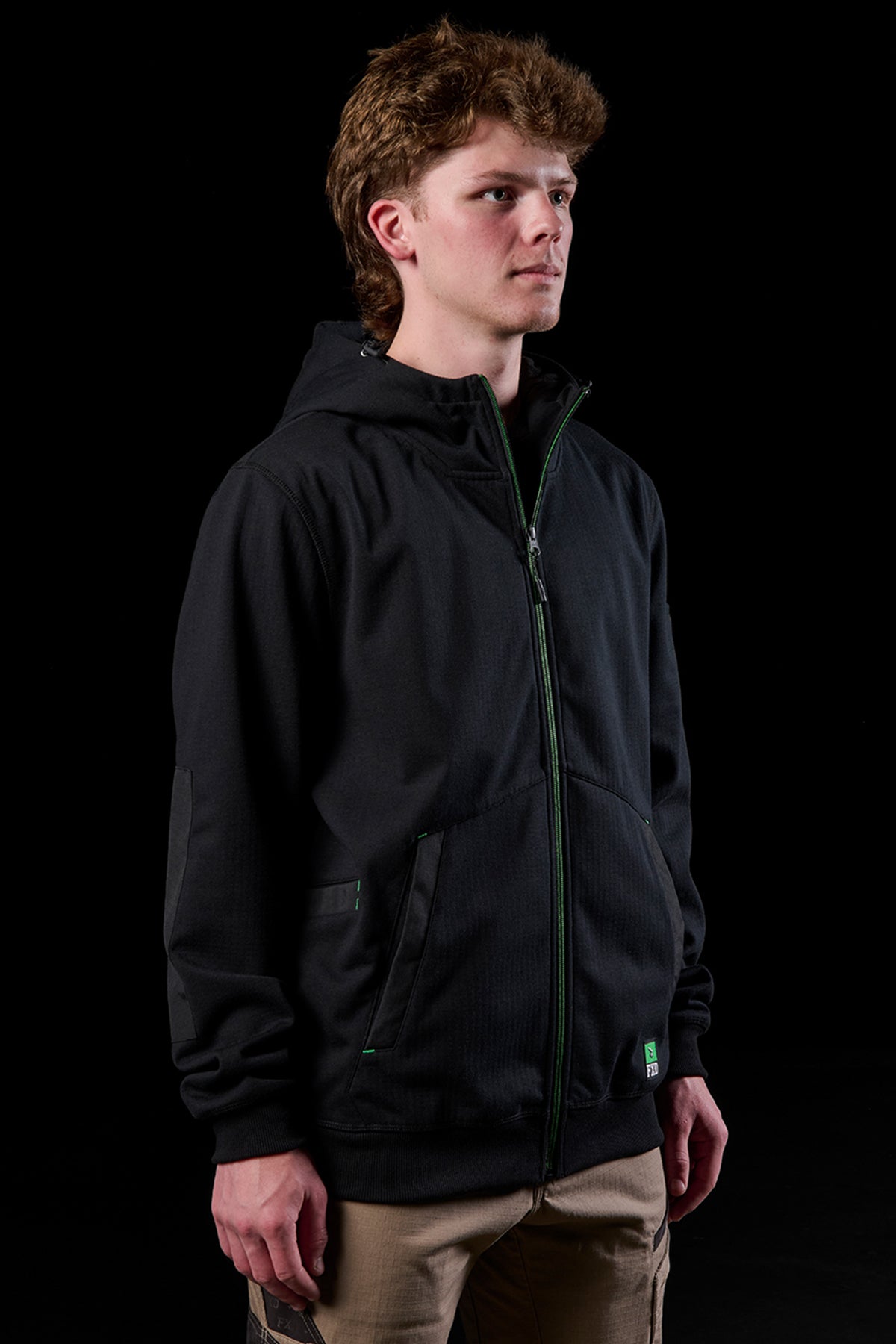 Front view of model in black WF-3 bonded fleece zip hoodie with green zipper and FXD logo on sleeve