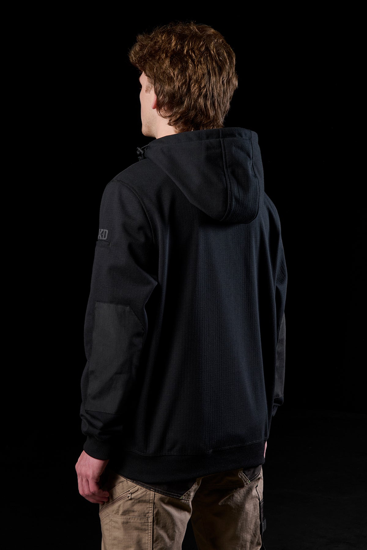 Back view of a person in a black WF-3 bonded fleece hoodie with hood up.