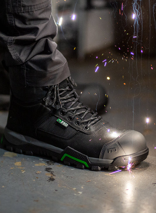 Person wearing black FXD work boots while welding.