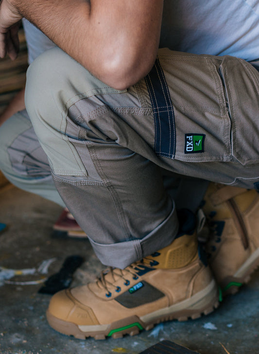 Person wearing khaki FXD work boots while working.