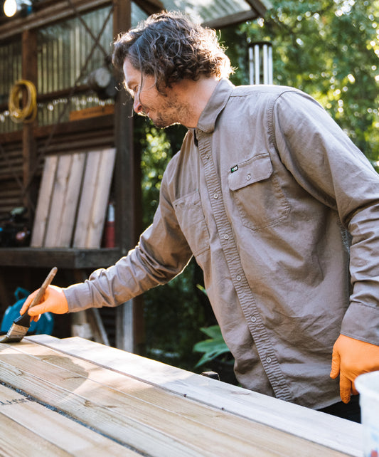 craftsman staining wood wearing the FXD long sleeve work shirt.