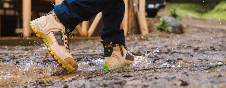 person working in muddy water wearing FXD WB1WP work boot 1 waterproof. 