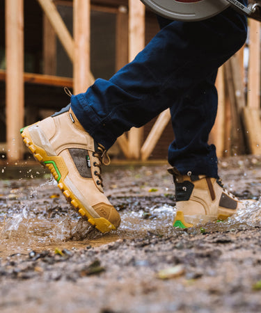 person working in muddy water wearing FXD WB1WP work boot 1 waterproof. 